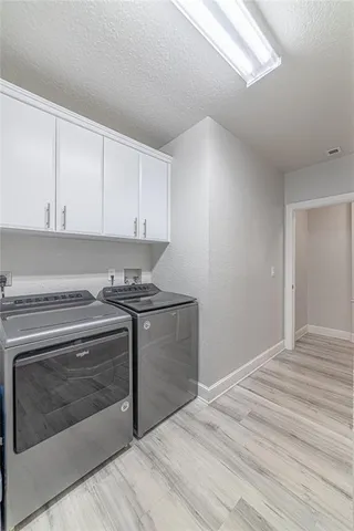 a kitchen with granite countertop white cabinets and stainless steel appliances