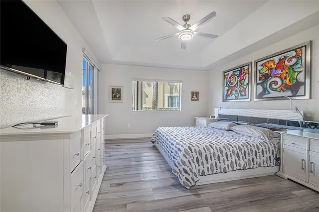 a bedroom with a large bed a flat tv screen and dresser