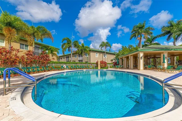 a view of a house with a yard and palm trees