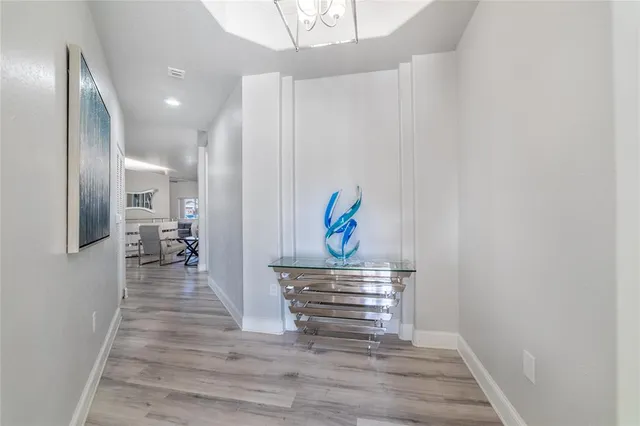 a hallway with wooden floor and cabinet