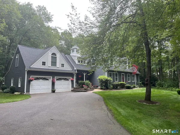 a front view of a house with a yard and trees