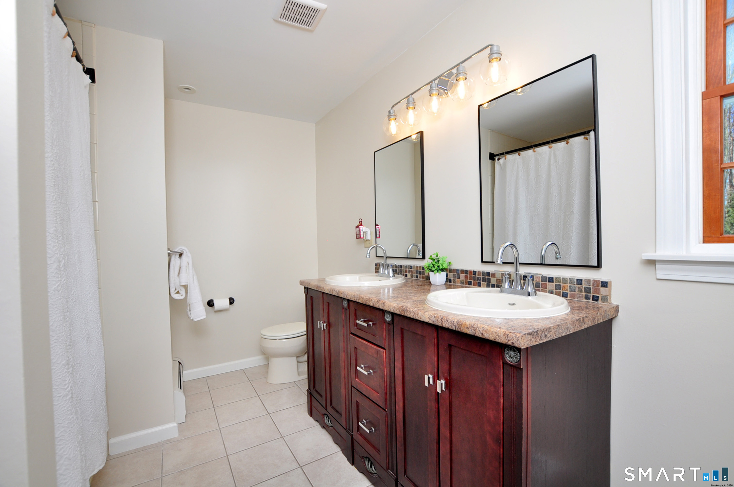 102 Petersen Road Granby, CT 06035 - Photo 28 of 40 a bathroom with a double vanity sink toilet and mirror
