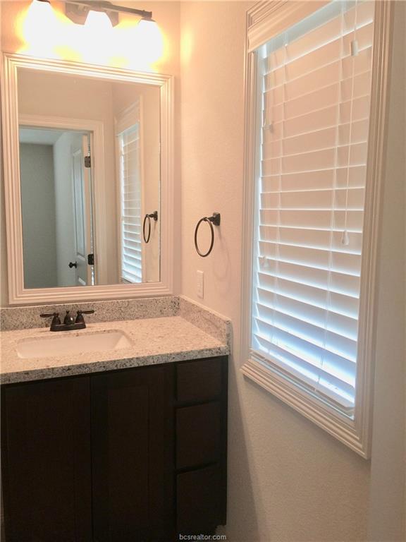 109 Ehlinger Drive Bryan, TX 77801 - Photo 12 of 25 a bathroom with a granite countertop sink a mirror and a shower
