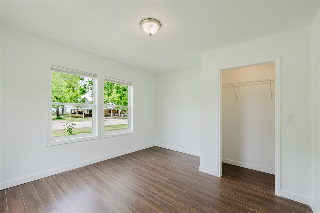 524 West Roberts Street Gorman, TX 76454 - Photo 25 of 35 an empty room with wooden floor and windows