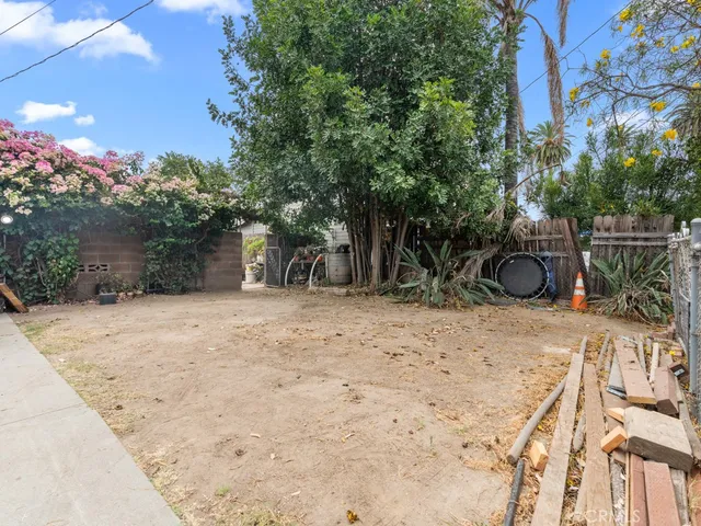 a backyard of a house with large trees and plants