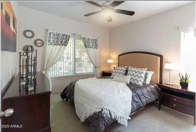 a bedroom with a bed lamp and a large window