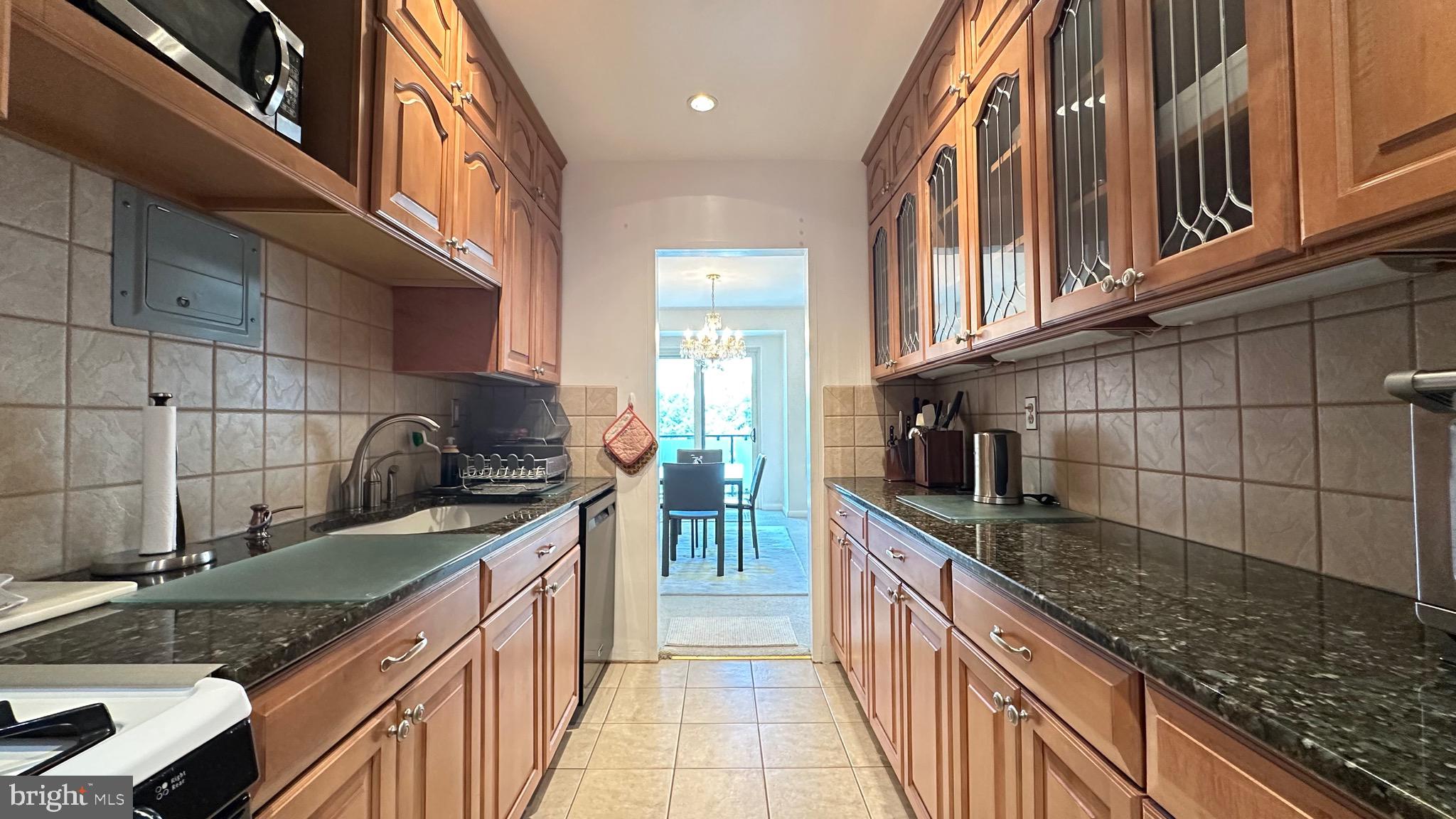 4201 Cathedral Avenue Northwest, Unit 1121E Washington, DC 20016 - Photo 15 of 25 a kitchen with stainless steel appliances granite countertop a sink and cabinets