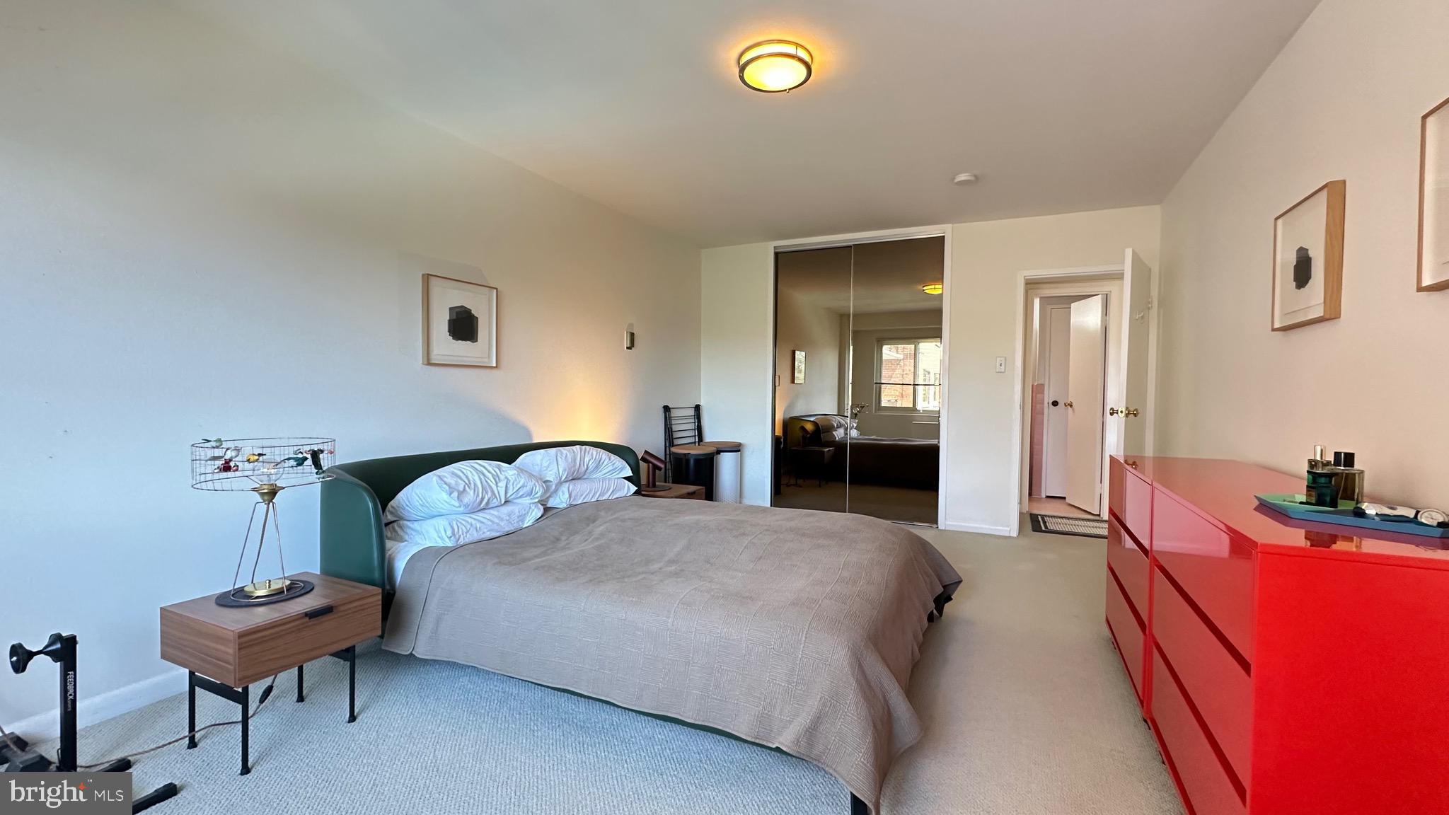 4201 Cathedral Avenue Northwest, Unit 1121E Washington, DC 20016 - Photo 17 of 25 a bedroom with a bed and a couch