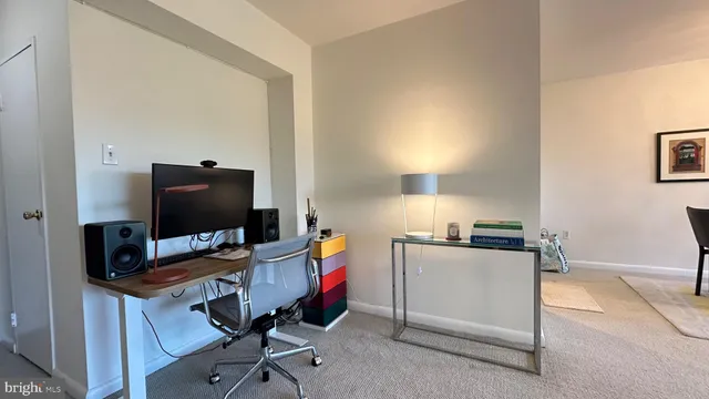 a view of a workspace with furniture and a window