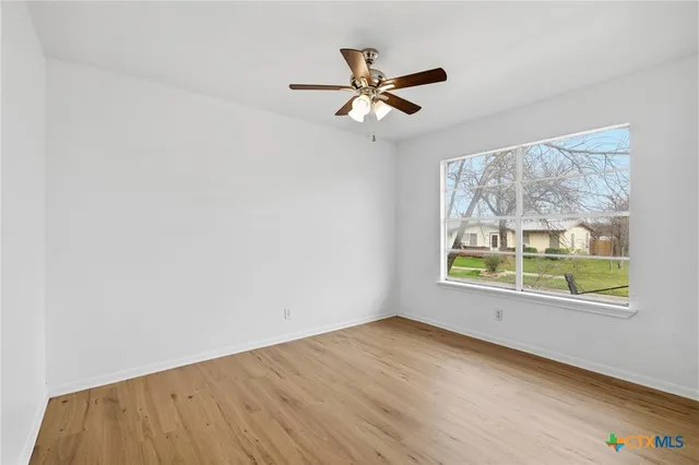 an empty room with window and wooden floor