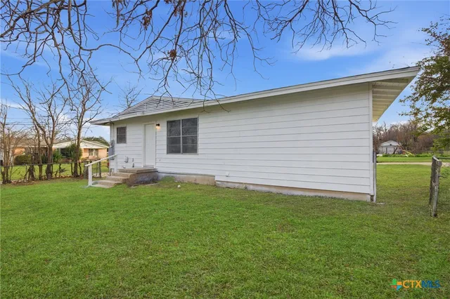 a backyard of a house with table and chairs