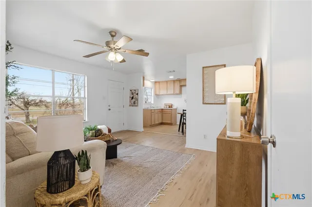 a living room with furniture a window and wooden floor