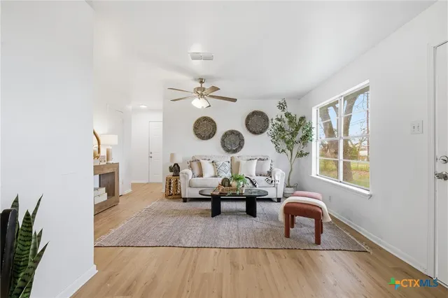 a living room with furniture and wooden floor