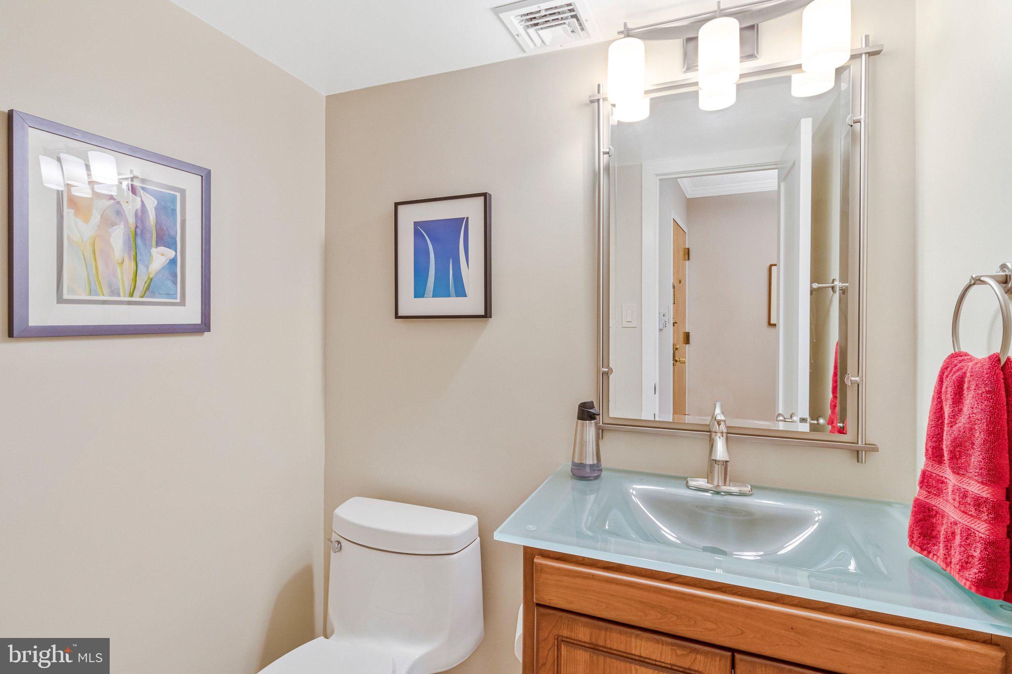 1101 South Arlington Ridge Road, Unit 706 Arlington, VA 22202 - Photo 11 of 59 a bathroom with a granite countertop toilet a sink and a mirror