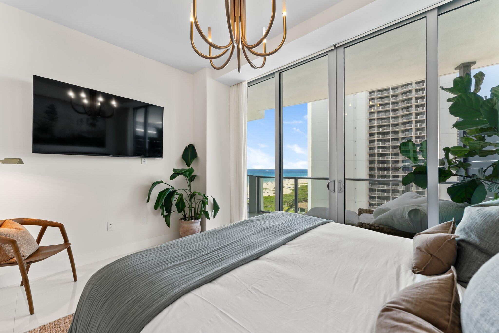 3100 North Ocean Drive, Unit H1006 Singer Island, FL 33404 - Photo 33 of 110 a bedroom with a bed a television and a large window