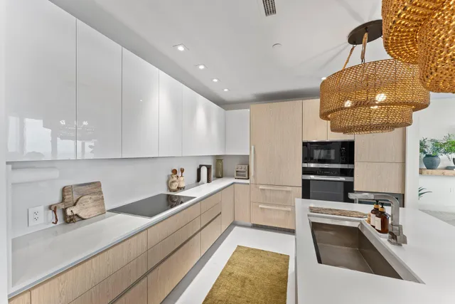 a kitchen with stainless steel appliances a stove a chimney a sink and cabinets