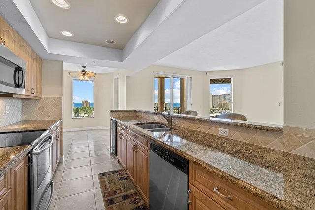 a kitchen with stainless steel appliances granite countertop a sink stove and cabinets