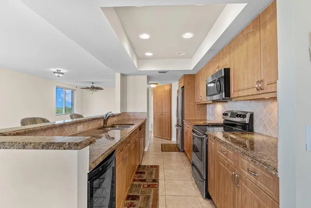 a kitchen with stainless steel appliances granite countertop a sink stove and refrigerator