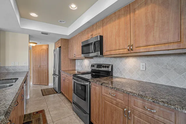 a kitchen with stainless steel appliances granite countertop a stove a sink and a microwave