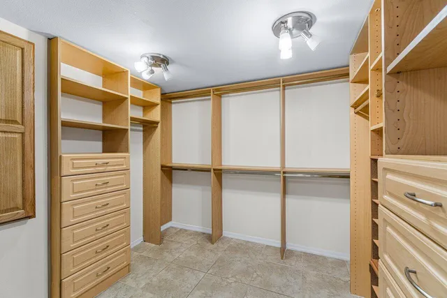 a view of walk in closet with empty racks