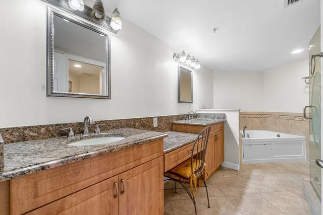 a bathroom with a granite countertop sink a toilet a mirror and bathtub