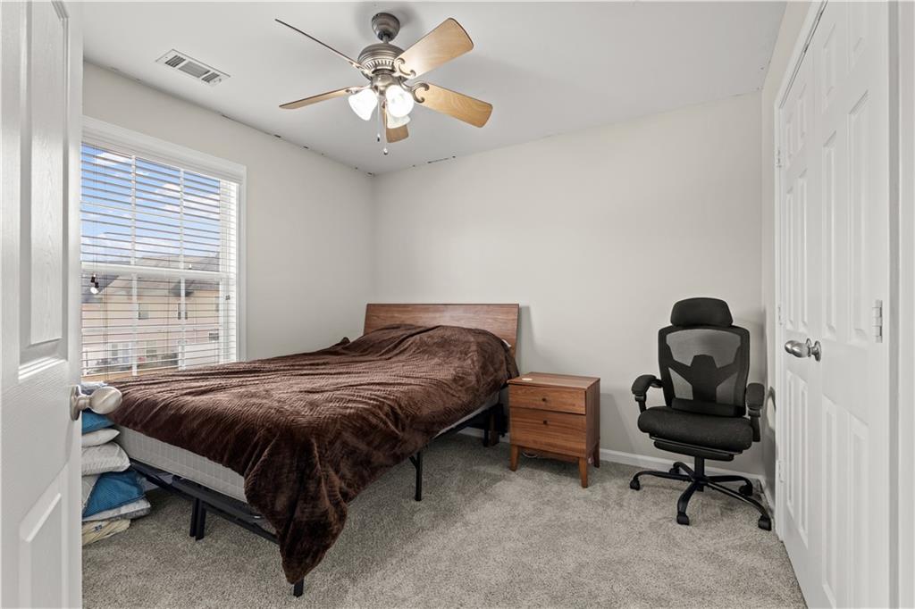 141 Mill Pond Crossing, Unit L3 Carrollton, GA 30116 - Photo 17 of 21 a bedroom with a bed and a chandelier