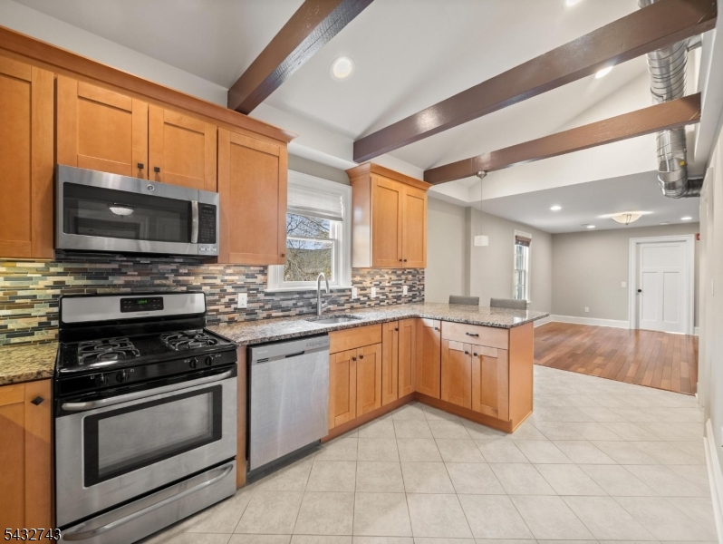 55 Main Street Chatham, NJ 07928 - Photo 8 of 14 a large kitchen with granite countertop a stove top oven microwave and cabinets