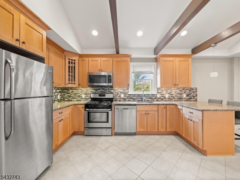 55 Main Street Chatham, NJ 07928 - Photo 9 of 14 a kitchen with granite countertop stainless steel appliances a refrigerator stove top oven and sink