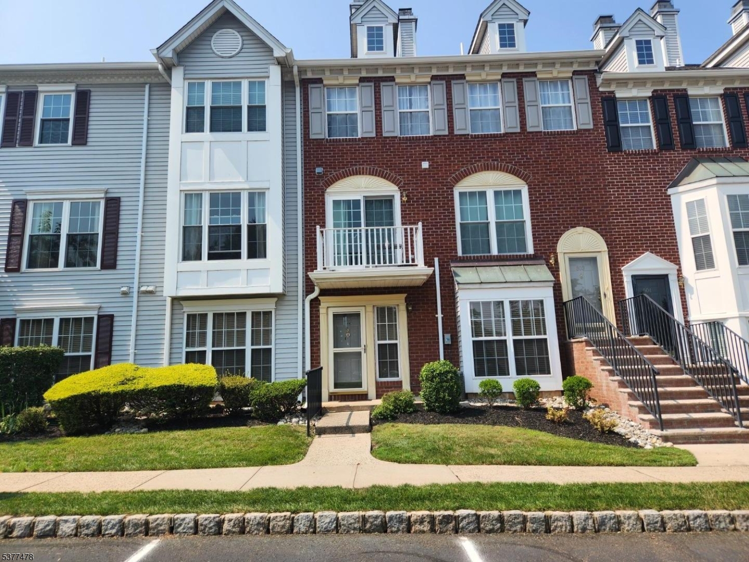 a front view of a residential apartment building with a yard