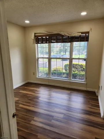 a view of room with wooden floor and windows