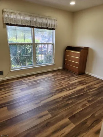 a view of room with wooden floor and windows