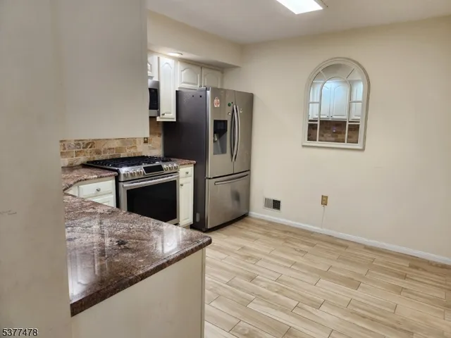 a kitchen with stainless steel appliances granite countertop a stove a refrigerator and a microwave
