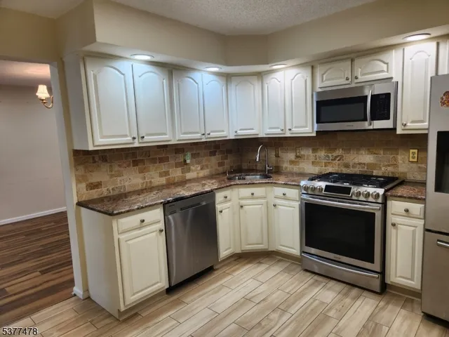 a kitchen with stainless steel appliances granite countertop a stove a microwave and a sink