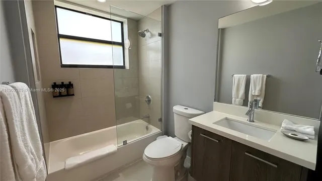 a bathroom with a granite countertop toilet sink and mirror