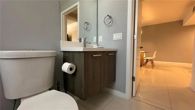 a bathroom with a granite countertop toilet sink and mirror