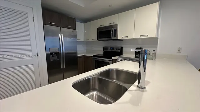 a kitchen with stainless steel appliances a microwave sink refrigerator and cabinets
