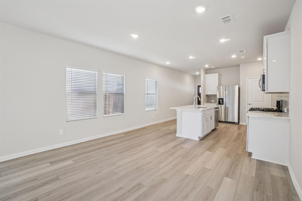 832 Sunflower Road Lavon, TX 75166 - Photo 17 of 39 a view of a kitchen with kitchen island a sink wooden floor and white stainless steel appliances