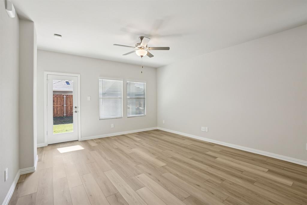 832 Sunflower Road Lavon, TX 75166 - Photo 20 of 39 an empty room with wooden floor chandelier fan and windows