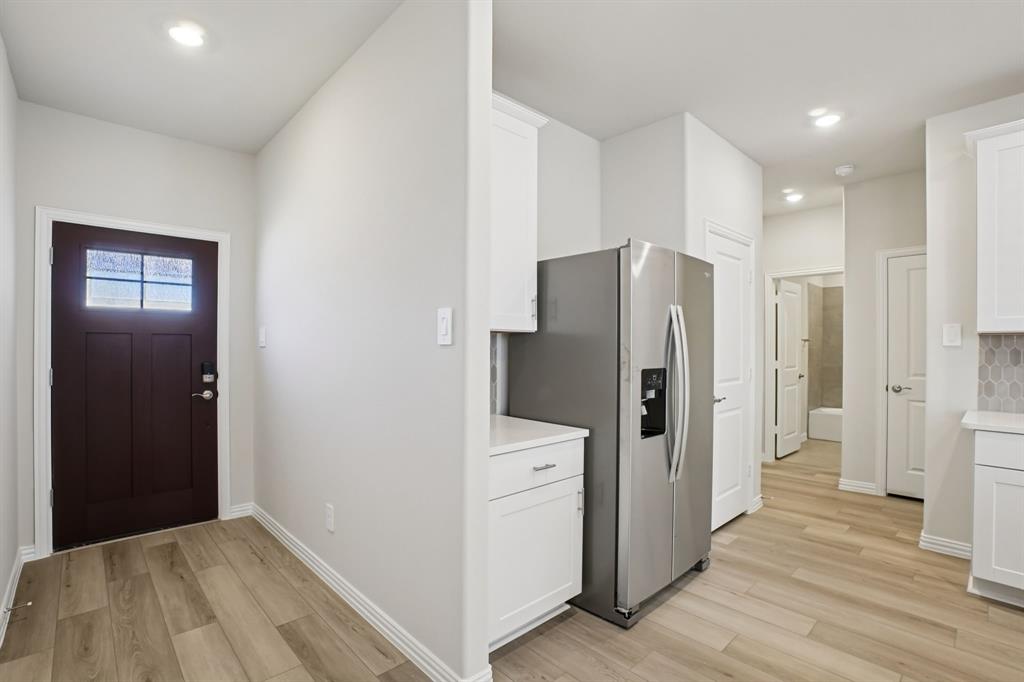 832 Sunflower Road Lavon, TX 75166 - Photo 7 of 39 a view of a kitchen with refrigerator and wooden cabinets