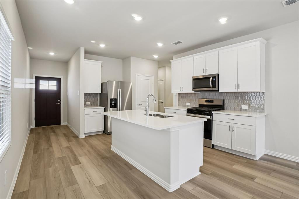 832 Sunflower Road Lavon, TX 75166 - Photo 9 of 39 a kitchen with white cabinets stainless steel appliances and sink
