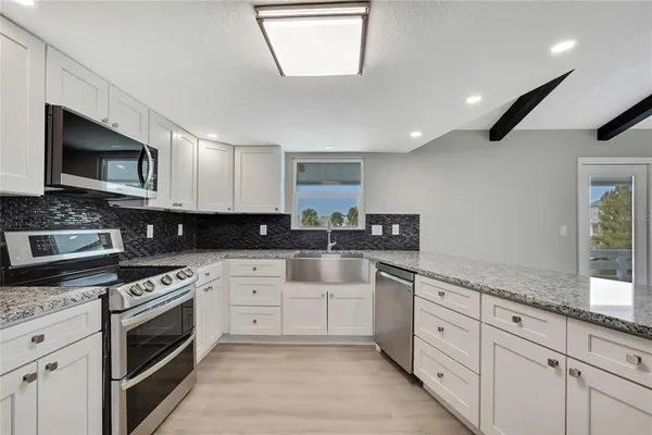 a kitchen with granite countertop a sink and a stove