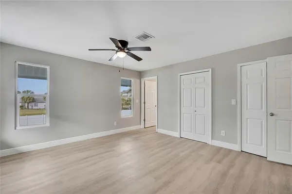 a view of room with wooden floor and ceiling fan