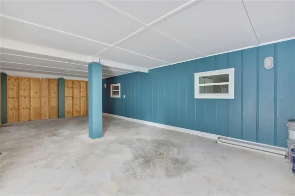 an empty room with wooden floor closet and windows