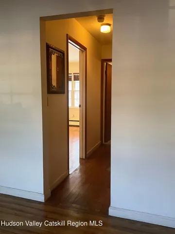 a view of hallway with a door and a mirror