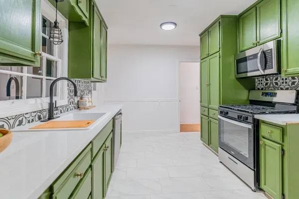 a kitchen with stainless steel appliances granite countertop a sink and a stove