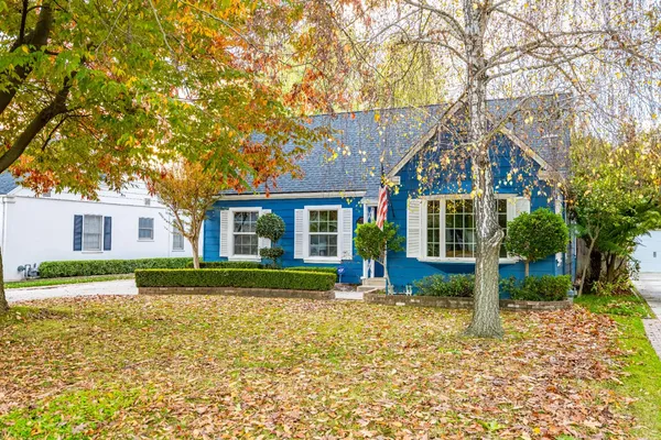 a front view of a house with a yard and trees