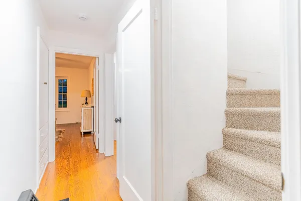 a view of a hallway with some couches and dining room view