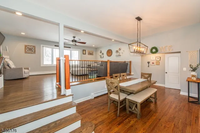 a view of a dining room and livingroom with furniture wooden floor a chandelier