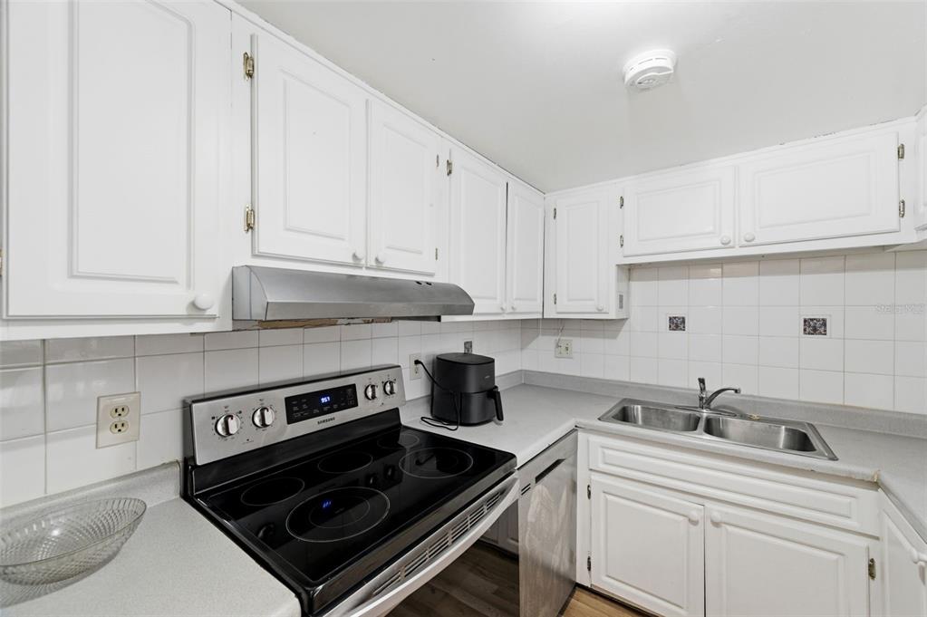 7701 Starkey Road, Unit 237 Seminole, FL 33777 - Photo 16 of 32 a kitchen with a stove and white cabinets