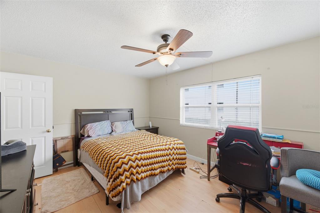 7701 Starkey Road, Unit 237 Seminole, FL 33777 - Photo 19 of 32 a bedroom with a bed and a chandelier